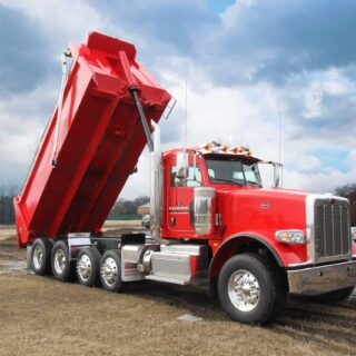 Red dump truck lifted by a hydraulic cylinder