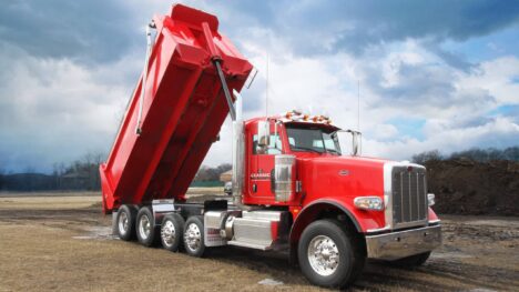 Red dump truck lifted by a hydraulic cylinder