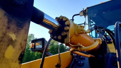 Yellow hydraulic cylinder being operated outside