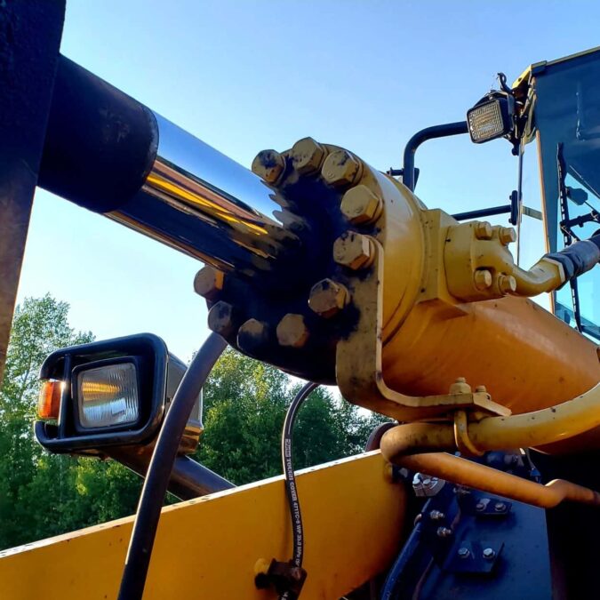 Yellow hydraulic cylinder being operated outside