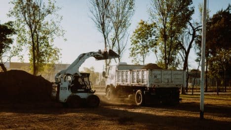 skidsteer-dumping-dirt-in-dump-truck